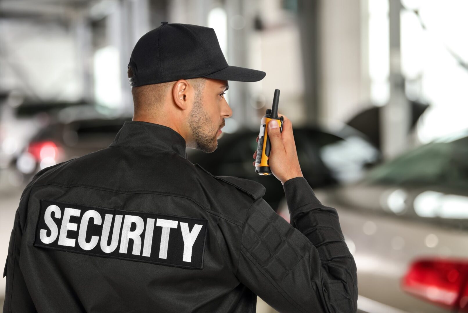 Male,Security,Guard,Wearing,Uniform,Using,Portable,Radio,Transmitter,At